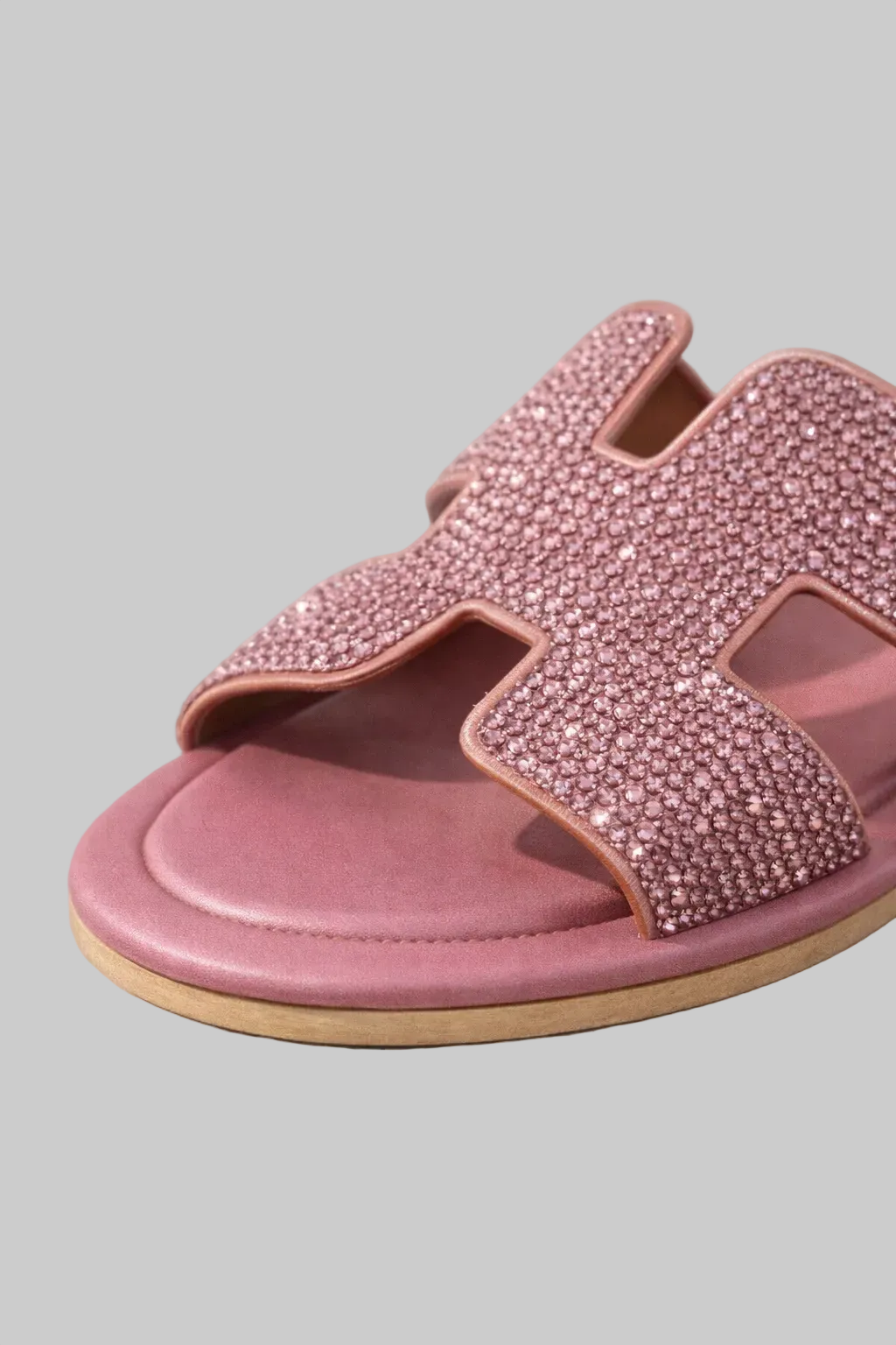 Pink sandal with embellishments on a gray background, featuring the brand 'POINTURE'.