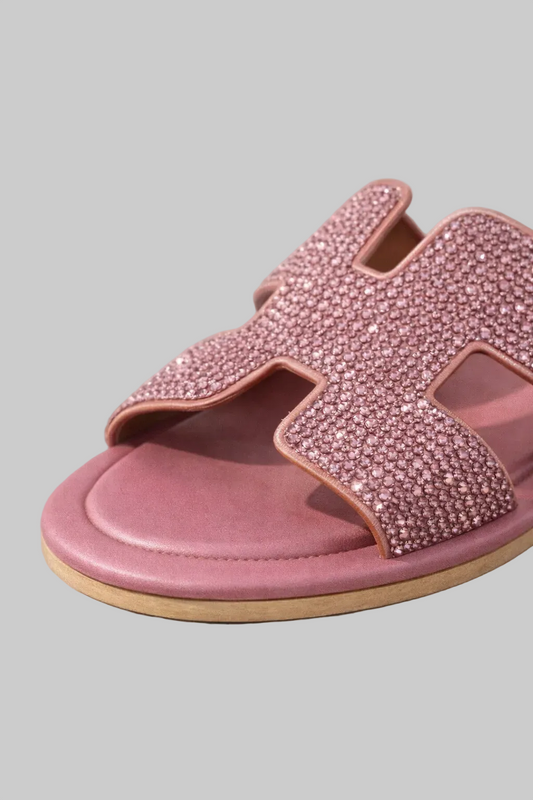 Pink sandal with embellishments on a gray background, featuring the brand 'POINTURE'.